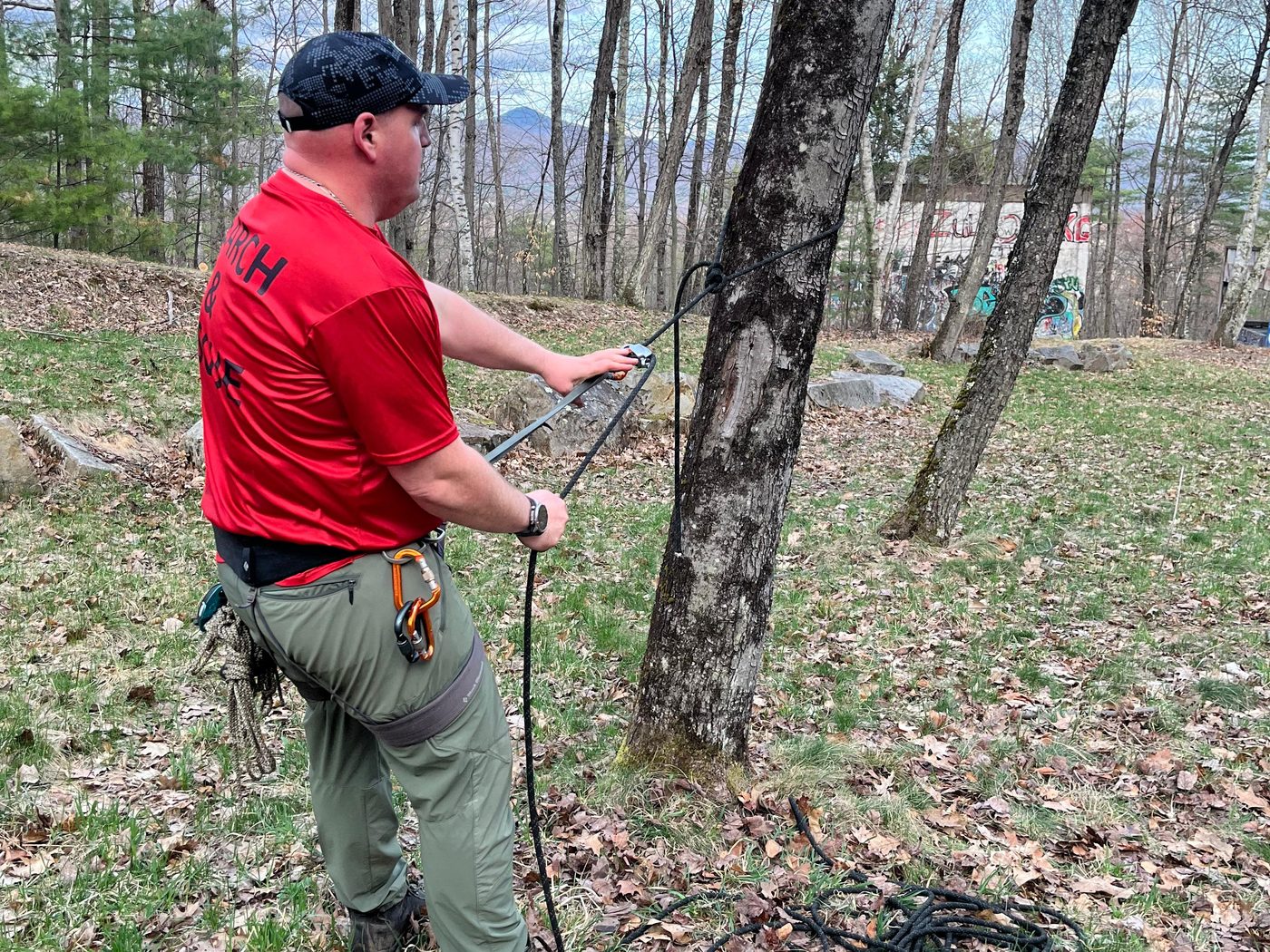 A KSAR member works a rope rescue system with carabiners and harness